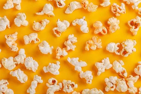 Box with popcorn on a yellow background Stock Photos