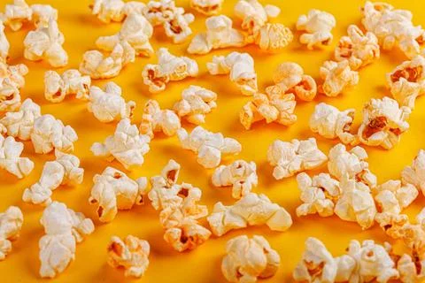 Box with popcorn on a yellow background Stock Photos