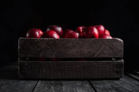 Box with red apples on black background. Stock Photos