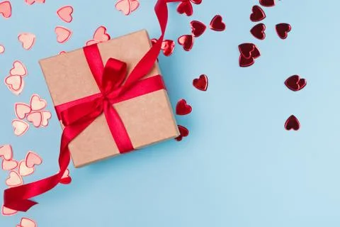 Box with red bow and small shiny hearts, top view. Foto stock