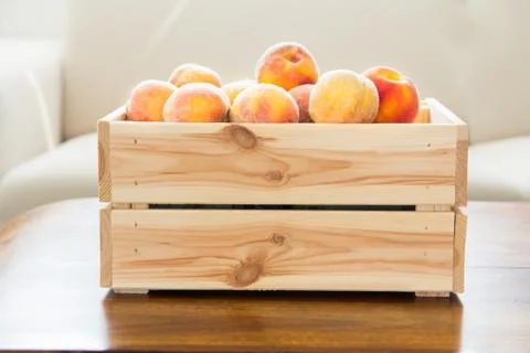 Box of ripe peaches on the table Stock Photos