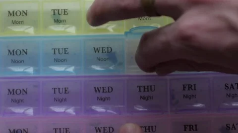 Box for the schedule of taking medications. A man's hand takes a pill. Stock Footage 84691715