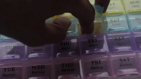 Box for the schedule of taking medications. A man's hand takes a pill. Stock Footage 84737670
