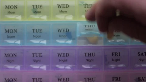 Box for the schedule of taking medications. A man's hand takes a pill. Stock Footage 84738044