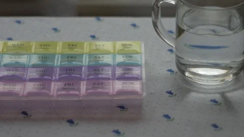 Box for the schedule of taking medications. A man's hand takes a pill. Stock Footage 84751969