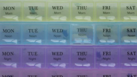 Box for the schedule of taking medications. A man's hand takes a pill. Stock Footage 84752222