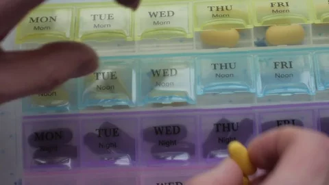 Box for the schedule of taking medications. A man's hand takes a pill. Stock Footage 84752370