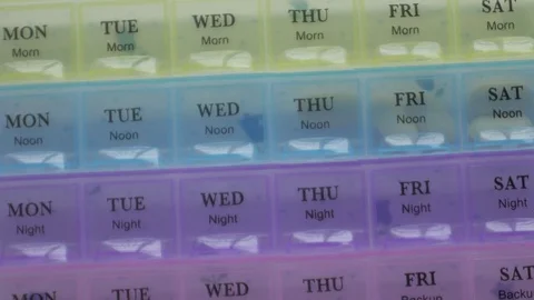 Box for the schedule of taking medications. A man's hand takes a pill. Stock Footage 84757634