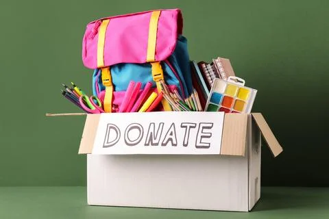 Box of school supplies for donation with backpack and art materials Stock Photos