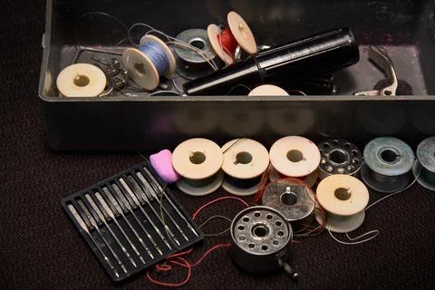 Box with spools of thread with needles for a sewing machine. Stock Photos