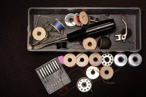 Box with spools of thread with needles for a sewing machine. Stock Photos