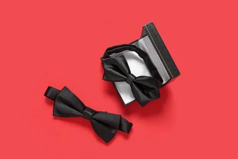 Box with stylish black bow ties on red background Stock Photos