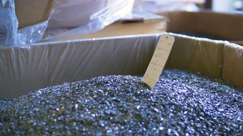 A box of tiny metal pieces with paper label sticking out 스톡 동영상 107319600