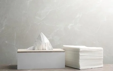 Box with tissues and stack of napkins on table Stockfoto's