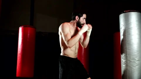Boxer with a beard trains by throwing punches in the gym. Stock Footage 139887737
