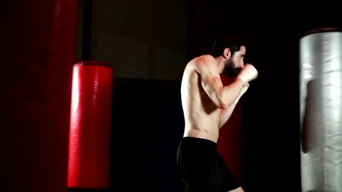 Boxer with a beard trains by throwing punches in the gym. Stock Footage 139887760