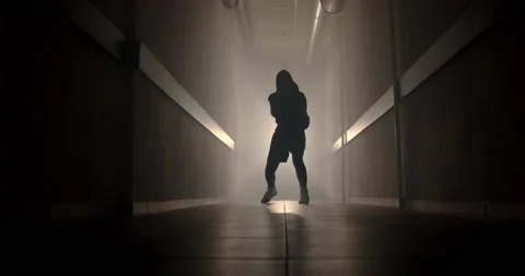 A boxer in a dark corridor with a backlight behind his back is fighting a shadow Stock-Footage 157898402