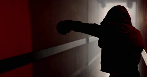 A boxer in a dark corridor with a backlight behind his back is fighting a shadow Stock Footage 157898704