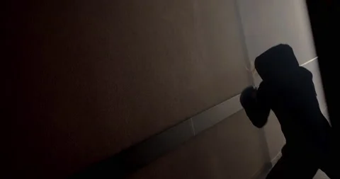 A boxer in a dark corridor with a backlight behind his back is fighting a shadow Stock Footage 157899070