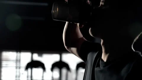 A boxer drinks water during a break in training. Slow motion, silhouette of a Stock Footage 256740138
