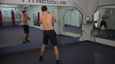 Boxer fulfills blows in front of a mirror Stock Footage 66344458