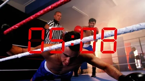 Boxer landing strike to win flooring opponent while ref counting and red Stock Footage 333539930