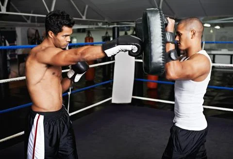 Boxer, man and instructor in boxing ring for training, workout and punching bag Stock Photos