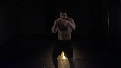 Boxer man on a black background trains striking Stock Footage 133022506