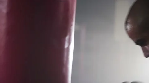 Boxer Man Hitting Heavy Red Bag during Boxing Workout in the Gym Stock Footage 174926566