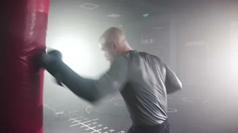 Boxer Man Hitting Heavy Red Bag during Boxing Workout in the Gym Stock Footage 174926610