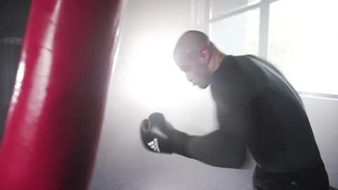 Boxer Man Hitting Heavy Red Bag during Boxing Workout in the Gym Stock Footage 174926793