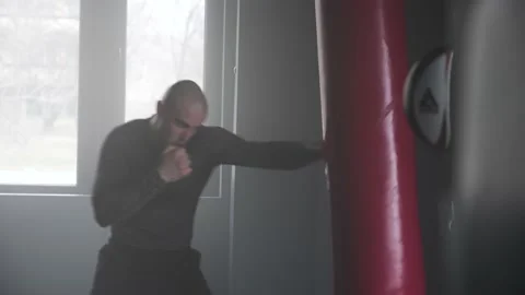 Boxer Man Hitting Heavy Red Bag during Boxing Workout in the Gym Stock Footage 174929202