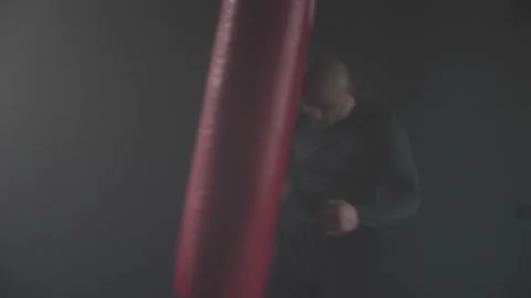 Boxer Man Hitting Heavy Red Bag during Boxing Workout in the Gym Stock Footage 174929240