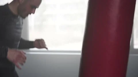 Boxer Man Hitting Heavy Red Bag during Boxing Workout in the Gym Stock Footage 174929293