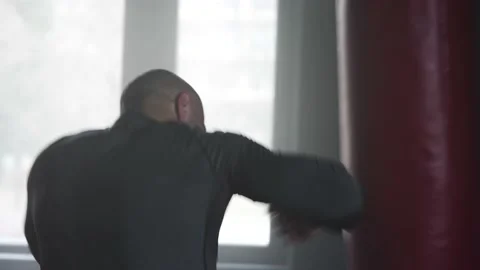 Boxer Man Hitting Heavy Red Bag during Boxing Workout in the Gym Stock Footage 174929356