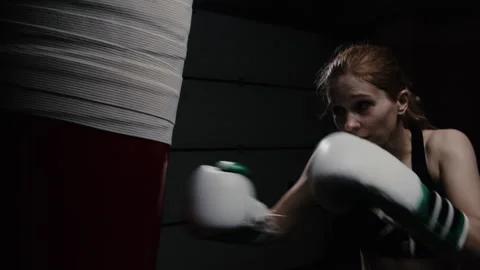 A boxer practices hard and fast punches on a punching bag in the gym  Stock Footage 277273196