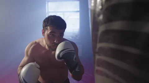 A boxer practices punches on a punching bag. A manifestation of aggression. Video stock 237915666