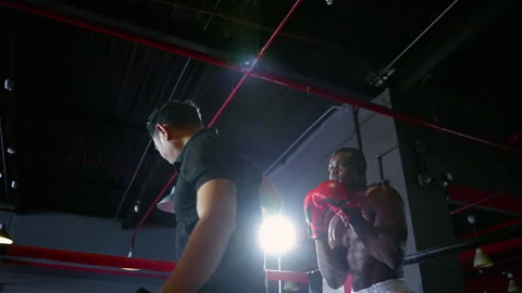 Boxer practicing punching with trainer on boxing ring Stock Footage 241347007