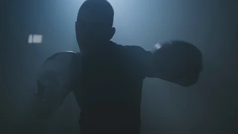 Boxer punching to camera. Silhouette of young boxer practicing boxing punches Stock Footage 119843414