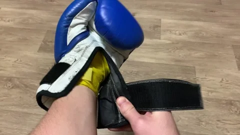 A boxer puts on a boxing glove before training Video stock 150001747