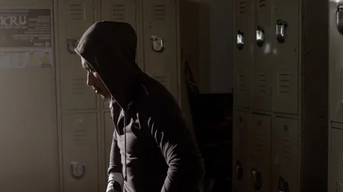 Boxer sitting on bench looking up in musty locker room 스톡 동영상 104539486