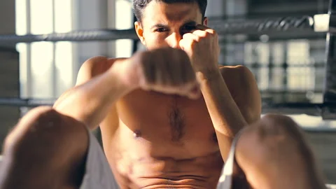 Boxer sitting on the floor at the boxing ring training. Stock Footage 98633210