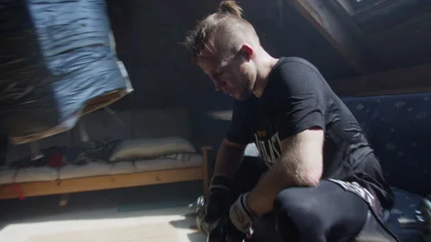 Boxer takes a break in attic apartment to recover and reflect on training Stock Footage 319988747