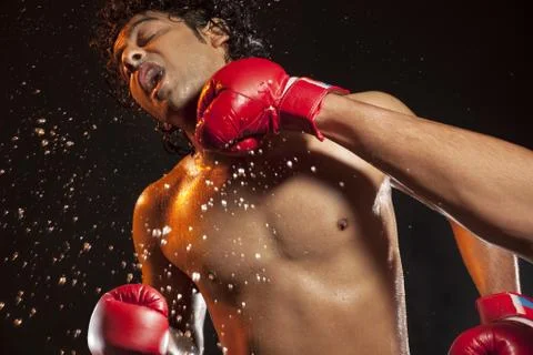 Boxer taking hit from opponent Stock Photos