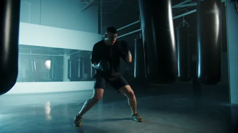 Boxer throwing punch at heavy bag in gym Stock Footage 309962331