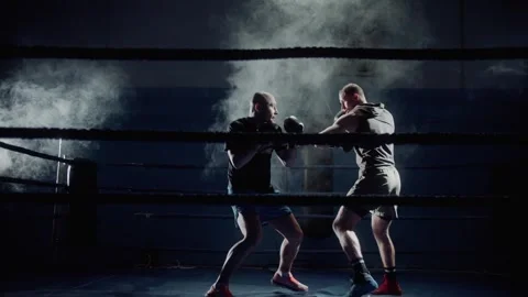 Boxer training with his trainer in low light gym. Boxer training in ring Stock Footage 315563831