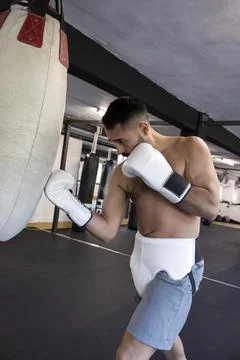 Boxer training, hitting punching bag in gym Stock-Fotos