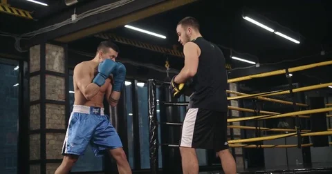 Boxer training uppercut punches in boxing club 4k video. Rrainer punch mitts Stock Footage 70404685