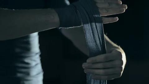 Boxer wraps his hands with Blue hand wrap before the fight training. Stock Footage 81520957
