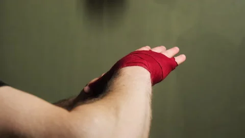 Boxer wraps wrists in preparation for hitting speed bag Stock Footage 306664642